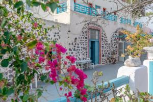 卡特瑞杜斯Caveland的一座带蓝色门和粉红色花朵的建筑