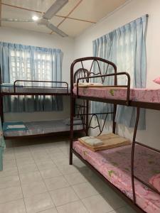 a room with three bunk beds in it at Shangrila House @ 香格里拉民宿 in Tawau