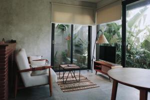 a living room with a tv and a chair and a table at T Lofts in Seminyak