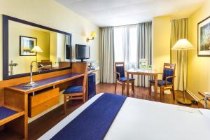 a hotel room with a bed and a desk at Holiday Inn Lisbon by IHG in Lisbon
