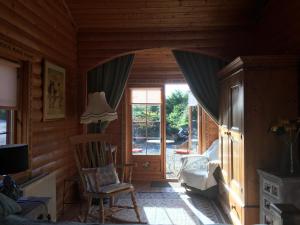 um quarto com uma janela, uma cadeira e uma televisão em Balnabrechan Lodge em Arbroath