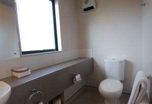baño con aseo y lavabo y ventana en Bella Vista Motel Kaikoura en Kaikoura
