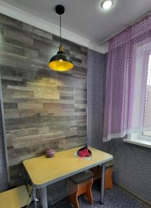 a dining room table with a wooden wall at Бухар Жырау 351, 2 комнатная квартира in Pavlodar