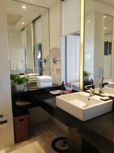 een badkamer met een wastafel en een grote spiegel bij Jinling Hotel Beijing in Beijing