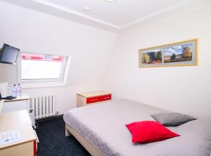 ein Schlafzimmer mit einem Bett mit einem roten Kissen darauf in der Unterkunft Blagodat Resort in Belokuricha