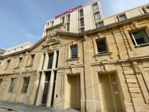 an old building with a sign on top of it at MEININGER Hotel Bordeaux Gare Saint-Jean in Bordeaux