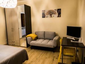 a bedroom with a couch and a desk with a computer at IL NIDO L'Aquila in LʼAquila