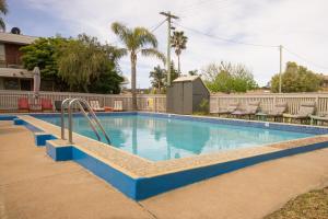 a swimming pool with a pool table and chairs at Kalindo Merimbula in Merimbula
