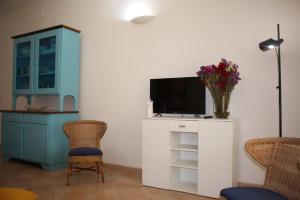 un soggiorno con TV, tavolo e sedie di Villa Malibù- spiaggia a 50m a Torre Lapillo