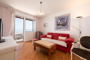 a living room with a red couch and a table at Seaview Apartment Bosnjak Opatija in Ičići