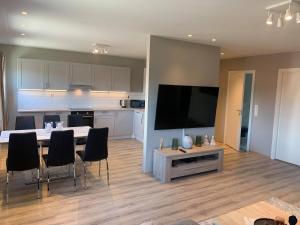 a living room with a kitchen and a table with chairs at Notodden Sentrum Apartment NO 6 in Notodden