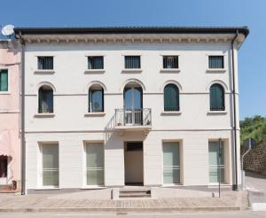 um grande edifício branco com uma varanda em Residence La Mason em Montebello Vicentino