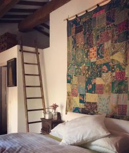 a bedroom with a tapestry hanging on the wall at At Home In Maremma in Istia dʼOmbrone