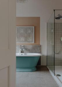 a bath tub sitting next to a toilet in a bathroom at No 15 by GuestHouse, Bath in Bath