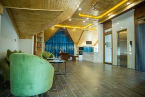 a living room with a green chair and a table at Win Villa Coffee in Da Lat