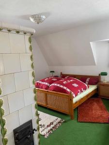 een slaapkamer met een bed met rode lakens en groene vloeren bij Berghaus Carlsfeld in Eibenstock