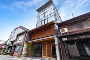 a tall building with windows on a street at Tabist KIYOMIZU Gion in Kyoto