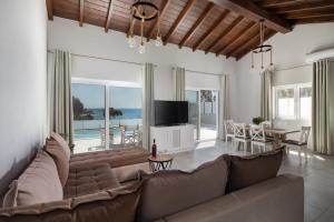 a living room with a couch and a table with a television at Villa Alonaki Bay in Halikounas