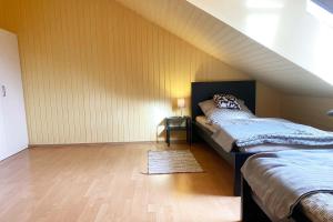 a attic room with two beds and a table at Ferienwohnung in Laichingen-Feldstetten in Laichingen