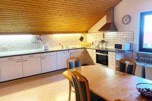 a kitchen with a wooden table and a wooden ceiling at Ferienwohnung in Laichingen-Feldstetten in Laichingen