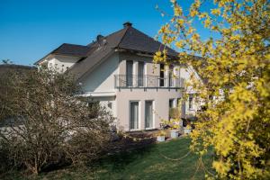a white house with a black roof at Roussel Hotel Restaurant in Bernkastel-Kues