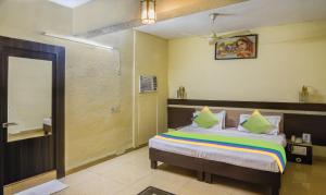 a bedroom with a bed and a bathroom with a mirror at Treebo Trend The Shagun Peer Gate in Bhopal