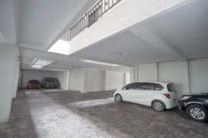a white car parked in a garage with two cars at D'Paragon Kijang Utara in Alastuwo