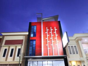 un edificio con una pared roja en el lateral. en D'Paragon Kijang Utara en Alastuwo