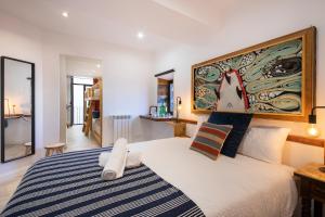 1 dormitorio con 1 cama y una gran pintura en la pared en Off Beat Guesthouse - Self-check-in - Sleep Conscious, en San Sebastián