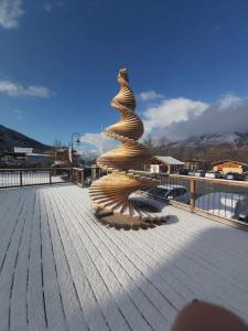 uma escultura de madeira no topo de um telhado em Hotel L'alpin em Landry