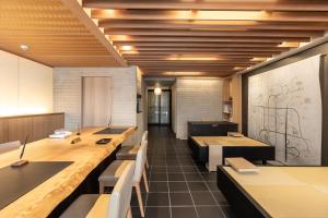 a dining room with tables and chairs and a chalkboard at Tabist KIYOMIZU Gion in Kyoto