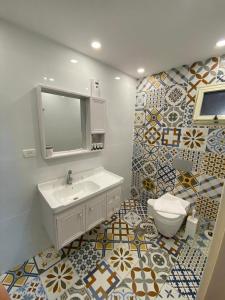 La salle de bains est pourvue d'un lavabo, de toilettes et de carrelage. dans l'établissement צפים על הים, à Neve Zohar