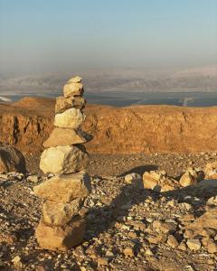 una pila de rocas sentadas en la cima de una montaña en צפים על הים en Neve Zohar