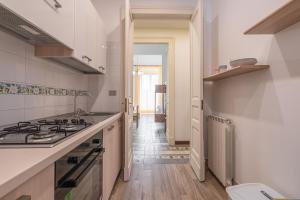 a kitchen with a stove and a sink and a hallway at Fermata Jonia in Giarre
