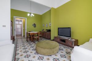 a living room with a television and a table at Fermata Jonia in Giarre