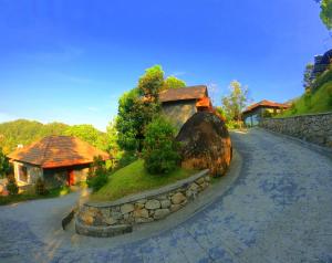uma casa com uma parede de pedra ao lado de uma estrada em The Wild Trails Munnar Resort em Munnar