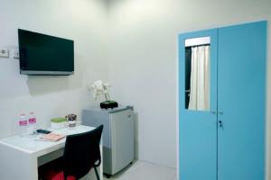a room with a desk and a small refrigerator at D'Paragon Bukit Sari in Semarang