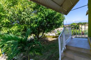 a stairway leading to a balcony with trees at Ocho Rios Emerald 2 Bed 10 mins ocho Rios 24hrs Hot Water Wi fi in Ocho Rios