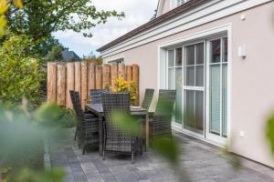 a patio with a table and chairs and a fence at Barther Str_10 a Austernfischer in Zingst