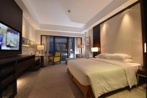 a hotel room with a large bed and a flat screen tv at Jinling Hotel Beijing in Beijing