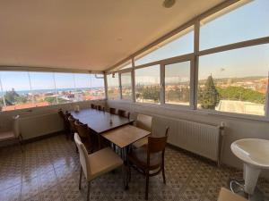 a dining room with a table and chairs and windows at Sakran Hotel in Yenişakran