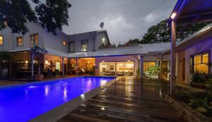 a house with a swimming pool at night at Vondelhof Guesthouse in Windhoek