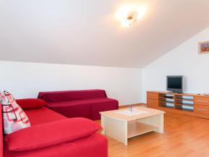 a living room with a red couch and a coffee table at Apartment Marija - VRB103 by Interhome in Vrbnik