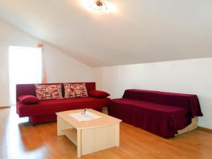 Sala de estar con sofá rojo y mesa de centro en Apartment Marija - VRB103 by Interhome, en Vrbnik