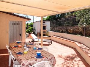 eine Terrasse mit einem Tisch und Stühlen unter einem Sonnenschirm in der Unterkunft Holiday Home Cristina-2 by Interhome in Santa Lucia