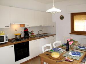 a kitchen with white cabinets and a table with a cake on it at Apartment Cristina-3 by Interhome in Santa Lucia