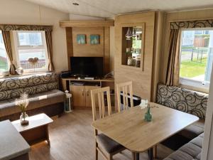 a caravan living room with a table and chairs at Beach Resort Kamperland - 434 in Kamperland