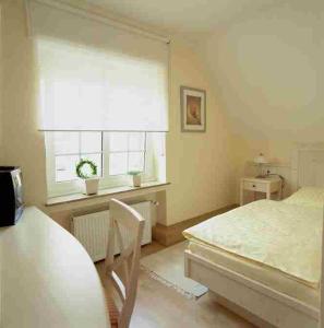 a bedroom with a bed and a window and a table at Hotel Veltrup in Laer