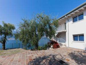 a house with a tree and a brick driveway at Apartment La Maison Blanche-2 by Interhome in Brenzone sul Garda