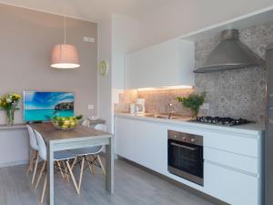 a kitchen with a table and a stove top oven at Apartment La Maison Blanche-2 by Interhome in Brenzone sul Garda
